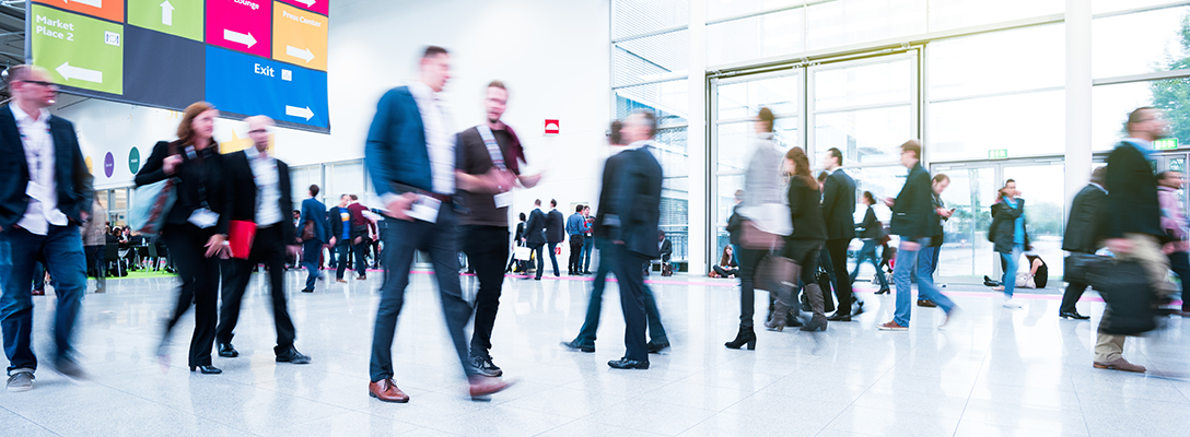 Blurred view of people walking through convention hallways