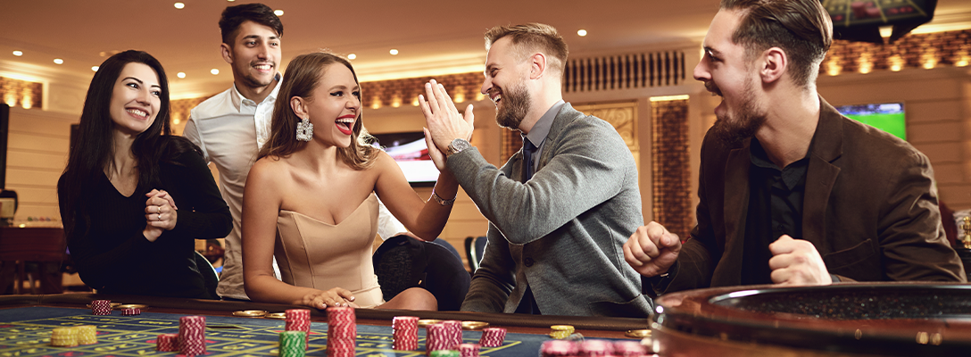 Happy Friends Playing Las Vegas Table Games in Casino