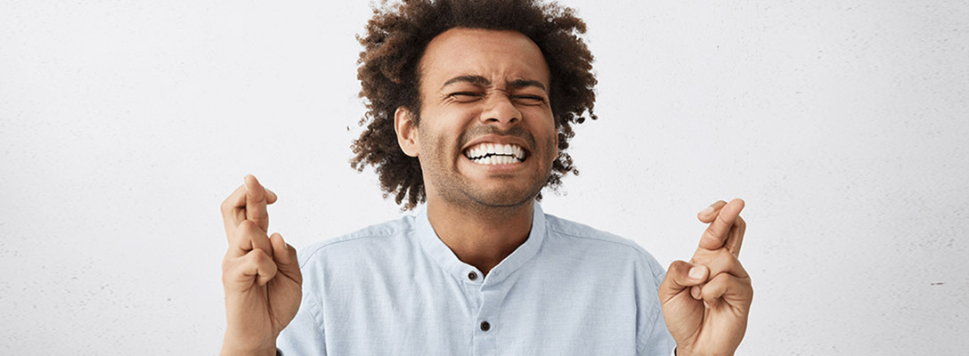 Man Crossing his Fingers Wishing Himself Good Luck