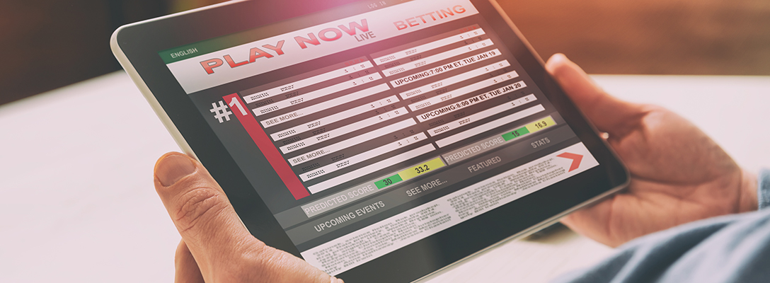 Man Using Sports Betting Apps on Tablet