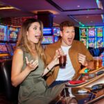 couple excited after winning on slots machines in casino