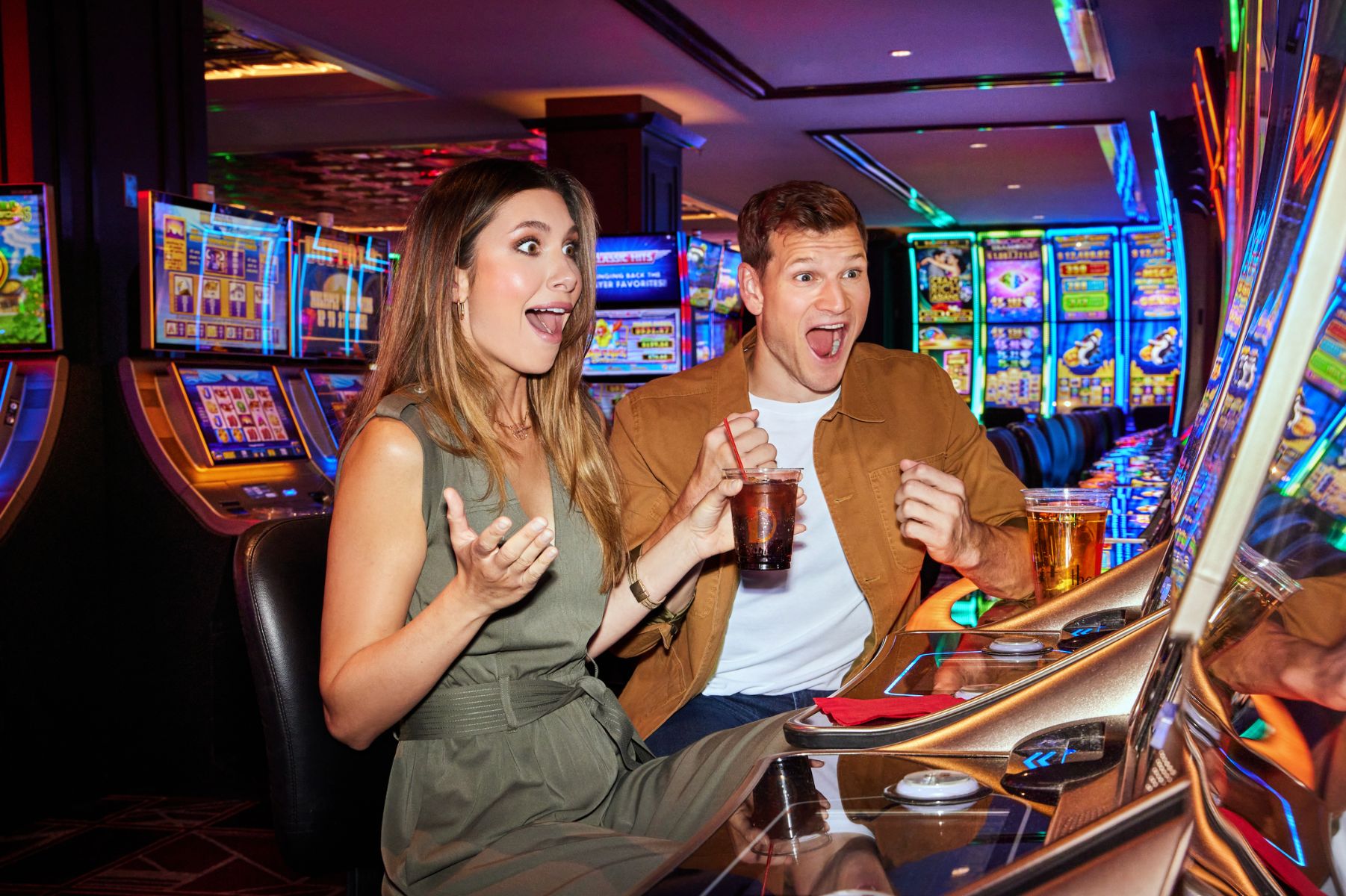 couple excited after winning on slots machines in casino