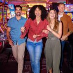 group off friends walking past slots machines in casino
