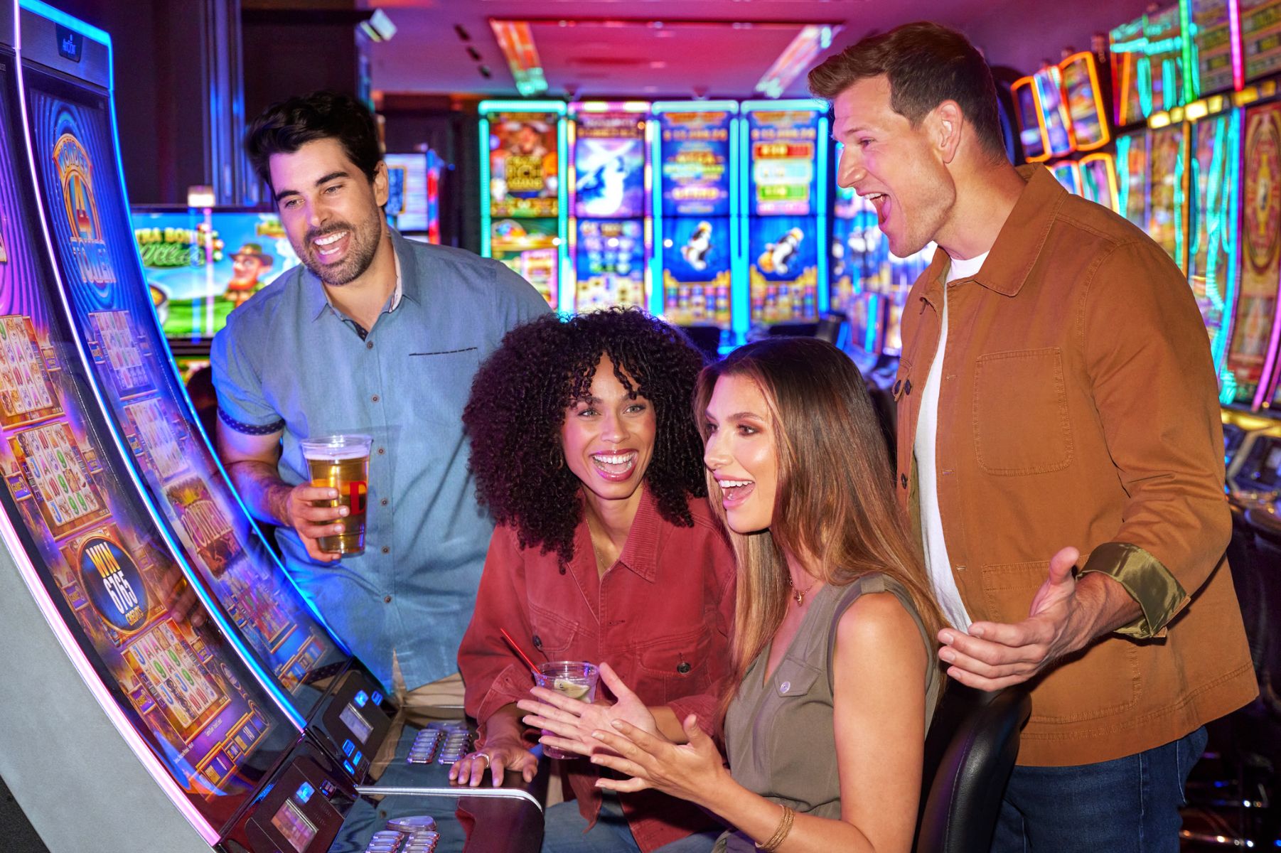 group of friends excited playing on slots machines in casino